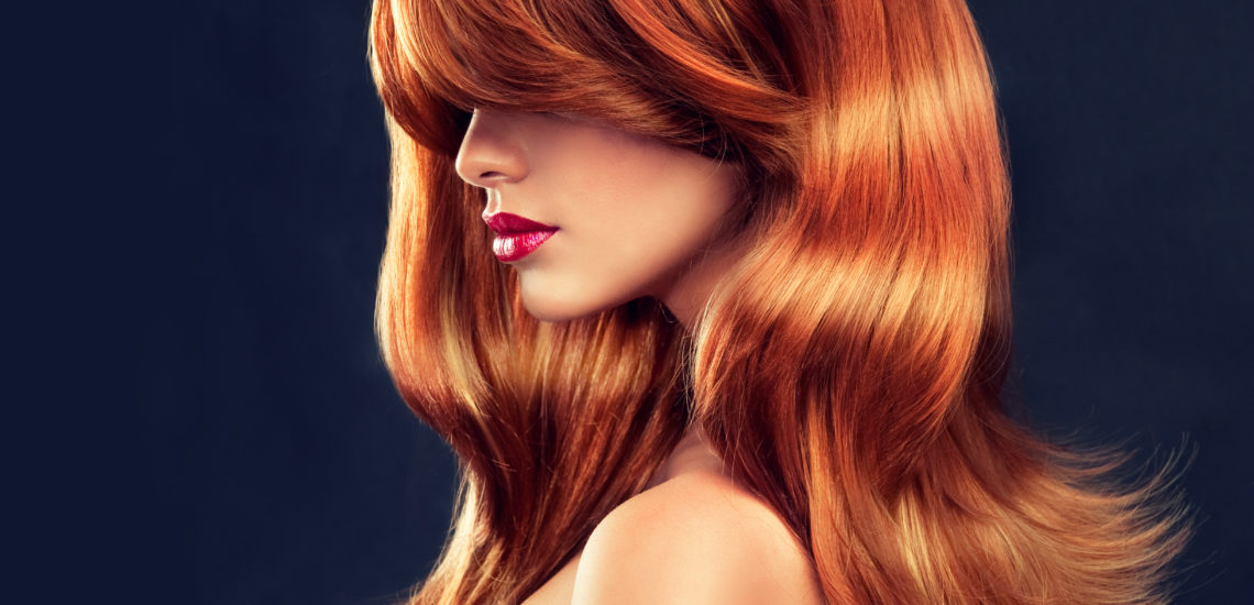 Beautiful model girl  with long red curly hair . Hairstyle and  cosmetics